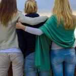 a group of three women standing next to each other