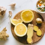 Flat lay of natural remedies including lemon, ginger, and garlic alongside pills.