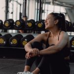 A woman sitting on the ground in a gym